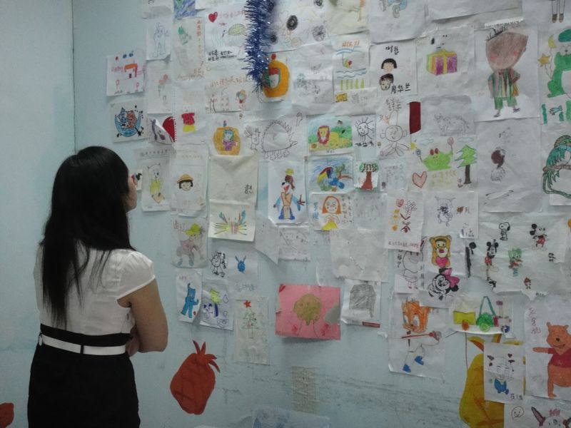 凝视着孩子们画作的疯子同学